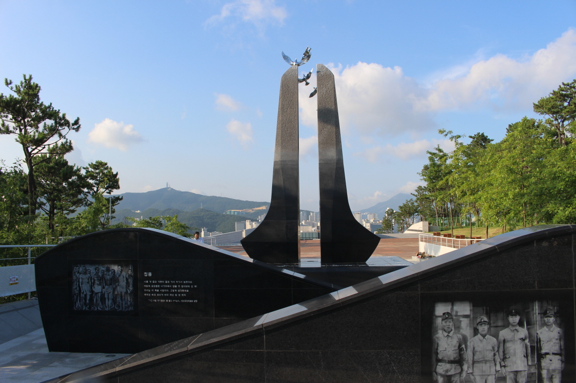 추도탑을 뒤에서 본 광경. 오른쪽 석벽에 군속(군무원)의 사진이 보인다.